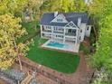 Aerial view of home with a private backyard pool, manicured lawn, and mature trees at 8813 Graham Rd, Denver, NC 28037