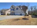 Beautiful two story home with a three car garage and well manicured front yard at 9007 Raven Top Dr, Mint Hill, NC 28227