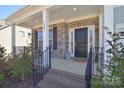 Charming front porch with stone accents, iron railings and a welcoming entrance at 9007 Raven Top Dr, Mint Hill, NC 28227