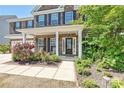 Charming brick home's front porch with elegant columns and lush landscaping at 9937 Travertine Trl, Davidson, NC 28036