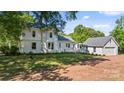 Expansive backyard with lush green grass, a detached garage, and mature trees providing ample shade at 127 Charlotte St, Mooresville, NC 28115