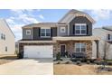 Charming two-story home featuring a mix of stone and siding, attached two-car garage and a welcoming front porch at 2039 Morning Gold Dr, Maiden, NC 28650