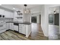 Modern kitchen with white cabinets, black countertops, and subway tile backsplash, flowing into a living area with outdoor access at 211 Heritage Blvd # 301, Fort Mill, SC 29715