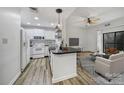 Bright, open living space featuring a modern kitchen with white appliances and an adjacent living room with a ceiling fan at 211 Heritage Blvd # 301, Fort Mill, SC 29715