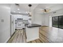 Bright, open living space featuring a modern kitchen with white appliances and an adjacent living room with a ceiling fan at 211 Heritage Blvd # 301, Fort Mill, SC 29715