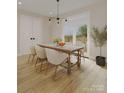 Bright dining room with hardwood floors, a wooden dining table with seating, and a sliding glass door to the outside at 4969 Fitzgerald Ave, Charlotte, NC 28213