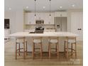 Modern kitchen featuring a spacious island with seating, stainless steel appliances, and stylish pendant lighting at 4969 Fitzgerald Ave, Charlotte, NC 28213