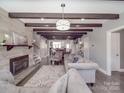 Open-concept living room with exposed beams, a fireplace, and comfortable seating at 605 Allen Way, Indian Trail, NC 28079