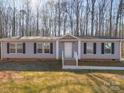 Charming single-story home featuring gray siding, black shutters, and a well-manicured lawn with mature trees at 185 Crystal Bay Dr, Mooresville, NC 28115