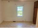 This bedroom features neutral paint, window with blinds, and a built in closet at 301 Louise St, Lancaster, SC 29720