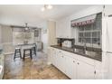 Bright and airy kitchen featuring white cabinets, a breakfast bar, and views into adjacent living spaces at 515 Burlington St, Wadesboro, NC 28170