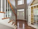 Bright foyer featuring hardwood floors, a staircase, and a view of the front entrance at 557 S Portman Ln, Fort Mill, SC 29708