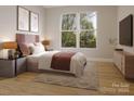 Serene bedroom with a large window offering a lush outdoor view, complemented by a stylish rug and tasteful decor at 6049 King Charles Ct, Charlotte, NC 28213