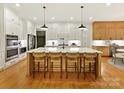 A bright kitchen with white cabinets, a large island with seating and stainless steel appliances at 911 Abilene Ln, Fort Mill, SC 29715