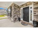 Elegant entryway with stone accents, a dark front door, and a welcoming covered porch at 121 Pine Eagle Dr, Rock Hill, SC 29732