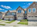 A row of attractive townhomes are showcased with well manicured lawns on a sunny day at 1213 Bhaltair Ln, Fort Mill, SC 29708