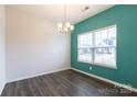 A bright dining room featuring a bold accent wall, wood floors, and a chandelier above at 1415 Troon Dr, Salisbury, NC 28144