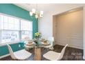 A bright dining room featuring a glass-top table, white chairs, and wood floors at 1415 Troon Dr, Salisbury, NC 28144