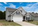 Side view of a charming two-story home with a gray exterior and a two-car garage at 1415 Troon Dr, Salisbury, NC 28144