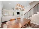 Open-concept dining area featuring hardwood floors, a statement chandelier and stair access at 253 W G St, Kannapolis, NC 28081