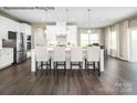 Stylish kitchen with a large island with bar stool seating, stainless steel appliances, and hardwood floors at 3010 Bramble Hedge Rd # 3271, Indian Trail, NC 28079