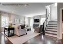 Inviting living room features neutral tones, hardwood floors, comfortable seating, and access to a staircase at 3010 Bramble Hedge Rd # 3271, Indian Trail, NC 28079