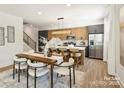 Contemporary eat-in kitchen with a breakfast bar, stainless steel appliances, modern lighting, and ample natural light at 3011 Yada Ln, Charlotte, NC 28208