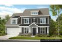 Two-story home featuring gray siding, black shutters, stone accents, a covered porch, and an attached garage at 3057 Tramore Dr, Harrisburg, NC 28075