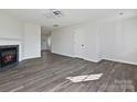 Open-concept living room featuring wood floors, modern light fixture, and fireplace, perfect for entertaining guests and relaxing at 3201 Decapolis Dr, Charlotte, NC 28215