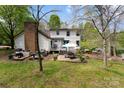 Spacious backyard with patio, brick chimney and lush greenery, perfect for entertaining at 3707 Banyon Nw Ct, Concord, NC 28027