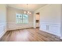 Elegant dining room featuring decorative molding, hardwood floors, and a modern chandelier at 3886 Horsham St, Indian Land, SC 29707