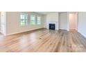 Bright living room with hardwood floors, a fireplace, and large windows offering natural light at 3886 Horsham St, Indian Land, SC 29707
