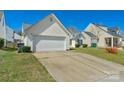Exterior image features an attached garage, paved driveway, and well-maintained lawn at 6821 Parkers Crossing Dr, Charlotte, NC 28215