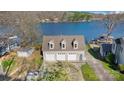 Aerial view of a lakeside home featuring a three-car garage and well maintained lawn at 938 Pinehaven Dr, New London, NC 28127
