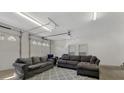 Garage transformed into a living area featuring comfortable sofas and concrete floors at 938 Pinehaven Dr, New London, NC 28127