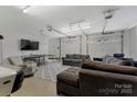 Spacious garage converted into a living area featuring comfortable sofas and a TV at 938 Pinehaven Dr, New London, NC 28127