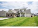 Charming single-Gathering home with stone accents, well-manicured lawn, and a welcoming covered front porch at 118 Heathrow Ln, Statesville, NC 28677