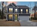 Two-story home features gray siding, black shutters, a two-car garage, and a bright green front door at 130 Big Oak Ln, Statesville, NC 28625