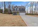 Two-story home features gray siding, black shutters, a two-car garage, a bright green front door, and a large yard at 130 Big Oak Ln, Statesville, NC 28625