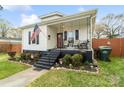 This charming home features a cozy porch and well-maintained landscaping at 1411 Congress St, Gastonia, NC 28054