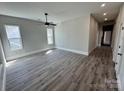 Spacious living area with modern ceiling fan, lots of windows, and new gray laminate flooring at 144 Walnut St, Chester, SC 29706