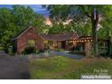 The home features a cozy outdoor patio with lighting and rustic details, perfect for evening relaxation at 1500 Griffith Rd, Monroe, NC 28112