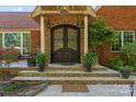 Elegant entryway with stone steps, columns, and arched double doors offering a grand welcome at 1500 Griffith Rd, Monroe, NC 28112