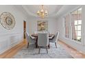 Bright dining room with wood floors, area rug, chandelier, round table and plenty of natural light at 15009 Lisha Ln, Charlotte, NC 28277