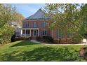 Charming two-story red brick home with a well-manicured lawn and a welcoming front porch at 15009 Lisha Ln, Charlotte, NC 28277