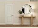 Stylish entryway with a round mirror, wooden console table, decor, and a white door, creating a welcoming ambiance at 1557 Croydon St, Indian Land, SC 29707