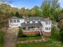 Charming two-story home with a brick foundation, white siding, covered front porch, and a separate two-car garage at 16421 Breckshire Dr, Huntersville, NC 28078