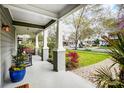 A view from the front porch that has white pillars, colorful plants and seating at 1717 Thomas Ave, Charlotte, NC 28205