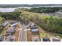 Neighborhood with homes, tree coverage and a lake in the distance at 18518 Lahaina Ln, Charlotte, NC 28278