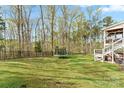 Spacious backyard featuring a well-maintained lawn, mature trees, and outdoor seating area at 18518 Lahaina Ln, Charlotte, NC 28278